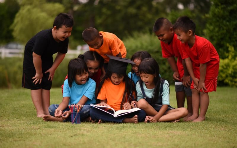 group-of-children-lying-reading-on-grass-field-2025-01-16-14-26-39-utc